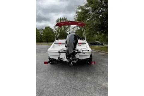 Slide: The Image of 2025 Tahoe T16 boat with red canopy, parked on a paved area, rear view. - 7