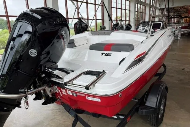 Slide: The Image of 2025 Tahoe T16 boat with red and white design, displayed indoors on a trailer. - 2