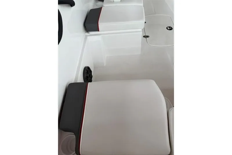 Slide: The Image of 2025 Tahoe T16 boat interior with white cushioned seating and speaker. - 11
