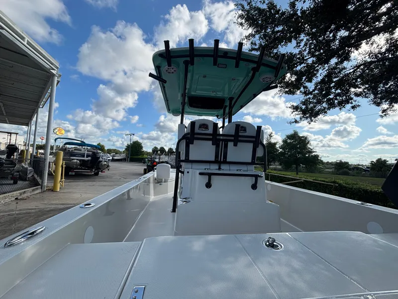 Slide: The Image of 2025 Ranger 2360 Bay boat with T-top, parked outdoors under a blue sky. - 2