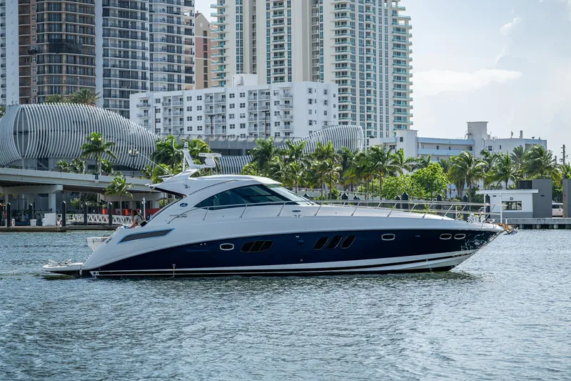 The Image of 2012 Sea Ray 540 Sundancer yacht cruising near urban waterfront skyline. - 1