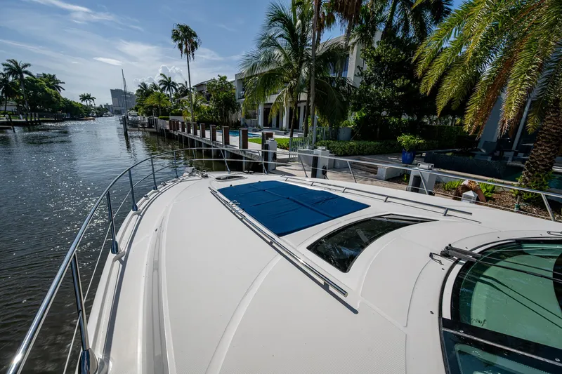 Slide: The Image of 2012 Sea Ray 540 Sundancer yacht docked by palm trees and waterfront homes. - 19