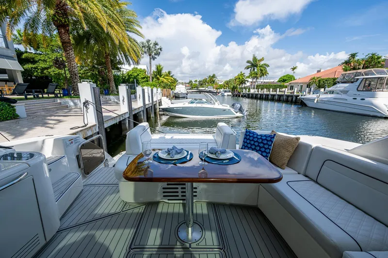 Slide: The Image of Luxurious 2012 Sea Ray 540 Sundancer yacht docked, featuring elegant outdoor seating and dining area. - 40