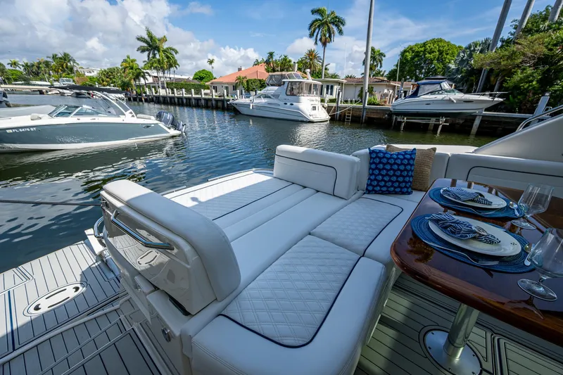 Slide: The Image of Luxurious 2012 Sea Ray 540 Sundancer yacht with elegant seating and dining area, docked in a scenic marina. - 42