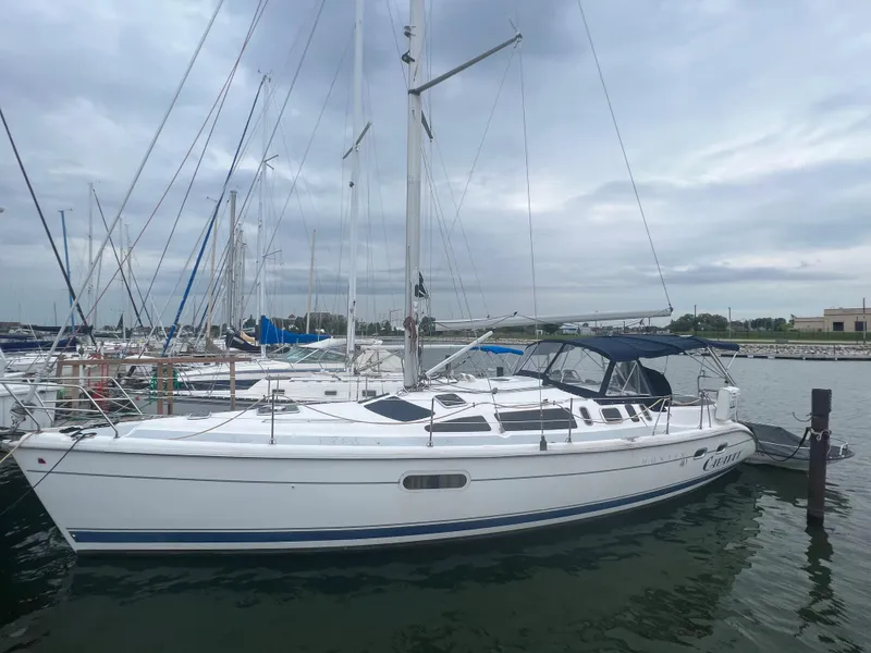 The Image of 2000 Hunter 410 sailboat docked at marina under cloudy sky. - 0