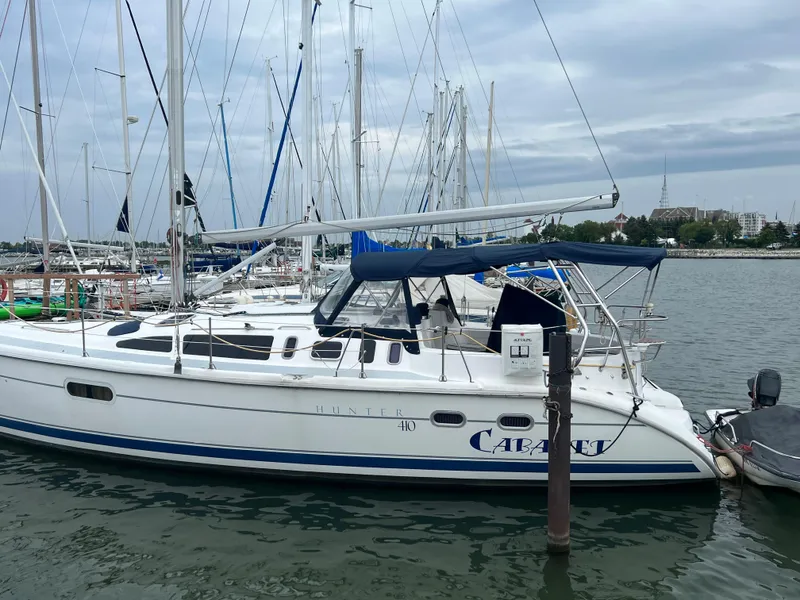 Slide: The Image of Sailboat docked in marina, Hunter 410 model, year 2000, with blue canopy. - 2