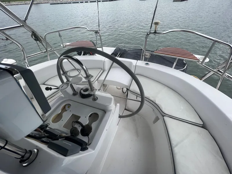 Slide: The Image of Cockpit of 2000 Hunter 410 sailboat with steering wheel and seating, overlooking water. - 21