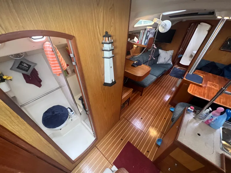 Slide: The Image of Interior of 2000 Hunter 410 sailboat with cozy seating and compact bathroom. - 26