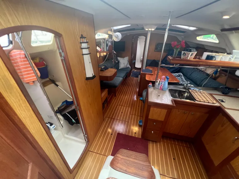 Slide: The Image of Interior of a 2000 Hunter 410 sailboat with wood finishes and cozy seating area. - 27