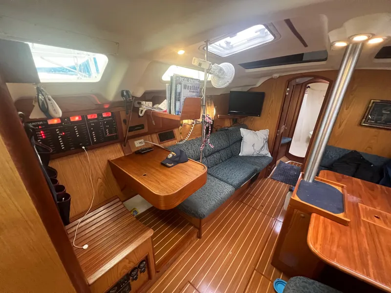 Slide: The Image of Interior of a 2000 Hunter 410 sailboat with wood finish and cozy seating area. - 28