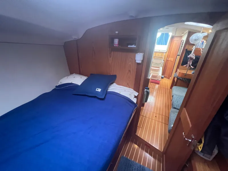 Slide: The Image of Cozy cabin interior of 2000 Hunter 410 sailboat with blue bedding and wooden finish. - 35