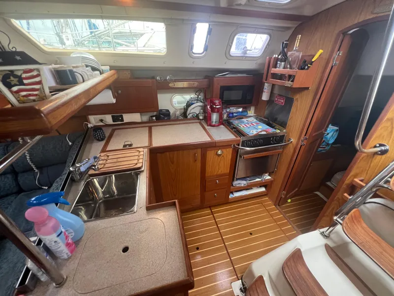 Slide: The Image of Interior of a 2000 Hunter 410 sailboat kitchen with wooden cabinetry and appliances. - 37