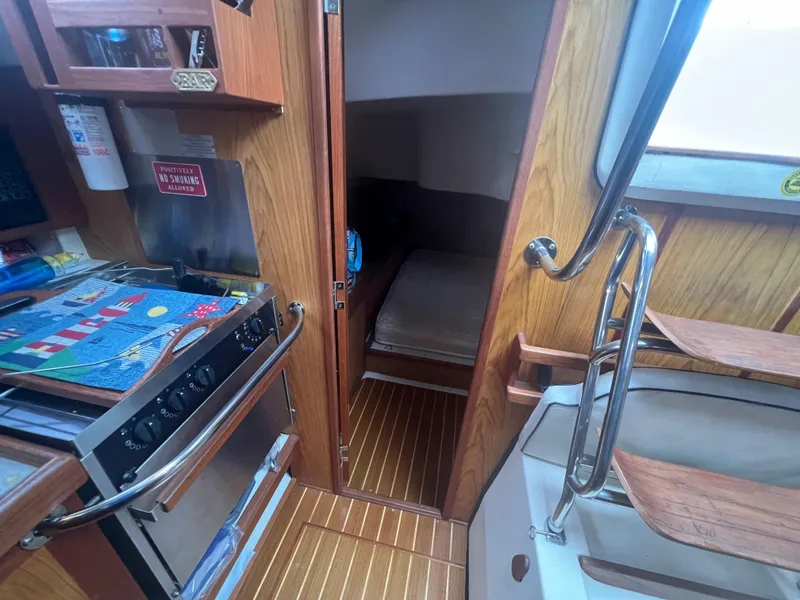Slide: The Image of Interior of a 2000 Hunter 410 sailboat, featuring a compact kitchen and cozy cabin. - 41