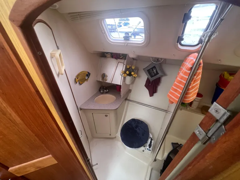Slide: The Image of Compact bathroom in 2000 Hunter 410 sailboat with sink, toilet, and window. - 44