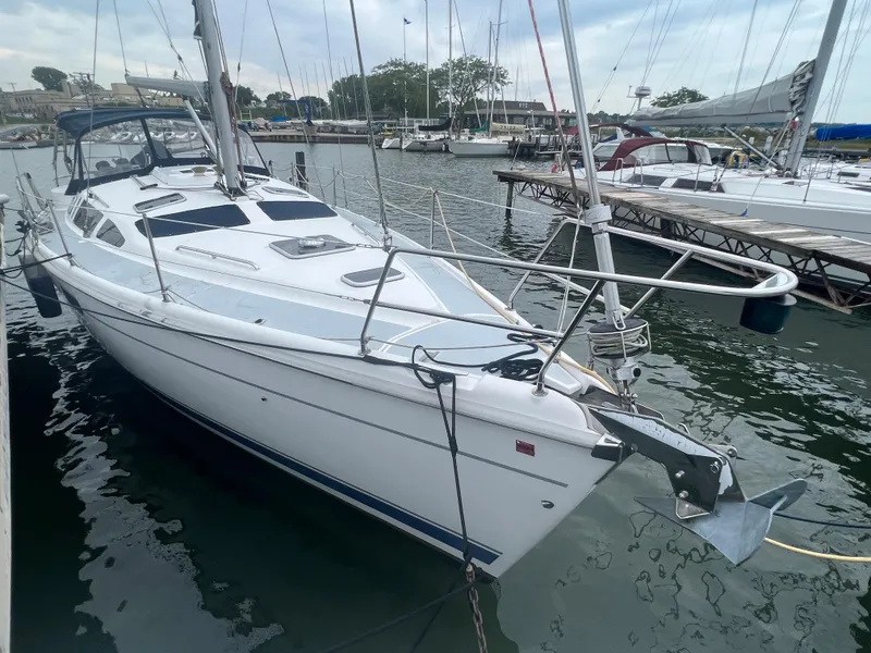 Slide: The Image of White 2000 Hunter 410 sailboat docked in marina, surrounded by other boats. - 5