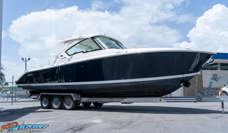 Slide: The Image of 2021 Pursuit DC 326 Dual Console boat on trailer under blue sky. - 10