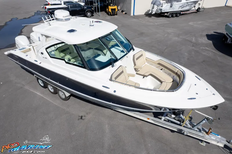 Slide: The Image of 2021 Pursuit DC 326 Dual Console boat on trailer in a marina setting. - 13