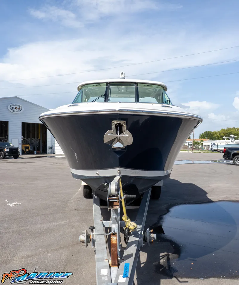 Slide: The Image of 2021 Pursuit DC 326 Dual Console boat on trailer, parked outdoors. - 14