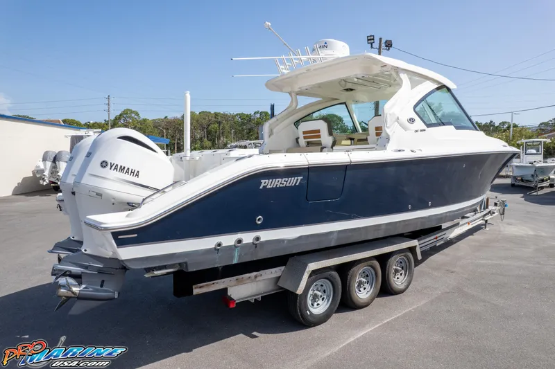 Slide: The Image of 2021 Pursuit DC 326 Dual Console boat on trailer, featuring Yamaha engines. - 19