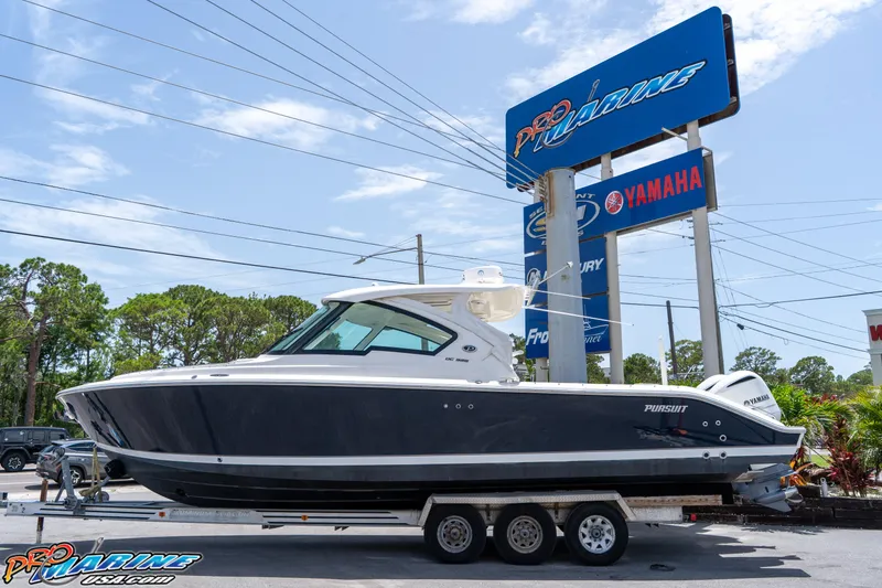 Slide: The Image of 2021 Pursuit DC 326 Dual Console boat on trailer at dealership. - 2