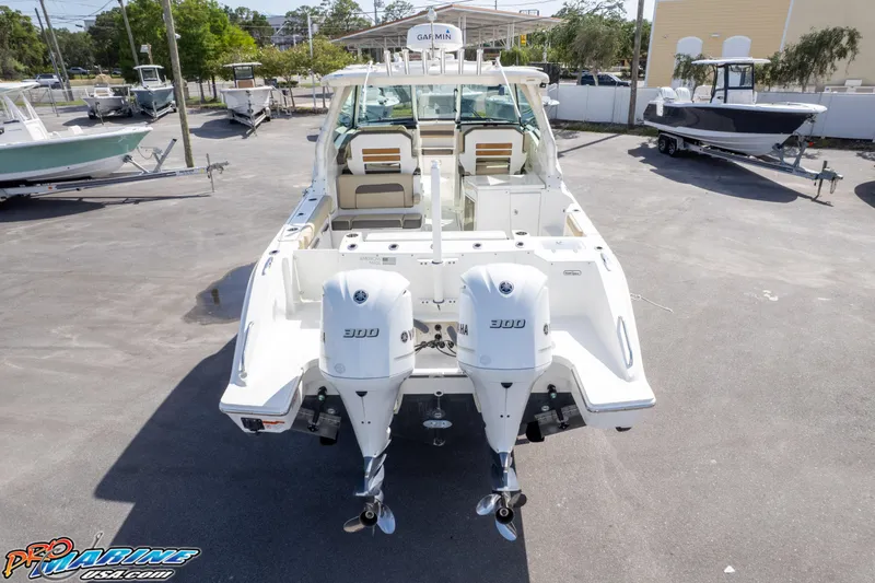Slide: The Image of 2021 Pursuit DC 326 Dual Console boat with twin engines, parked in a marina. - 20