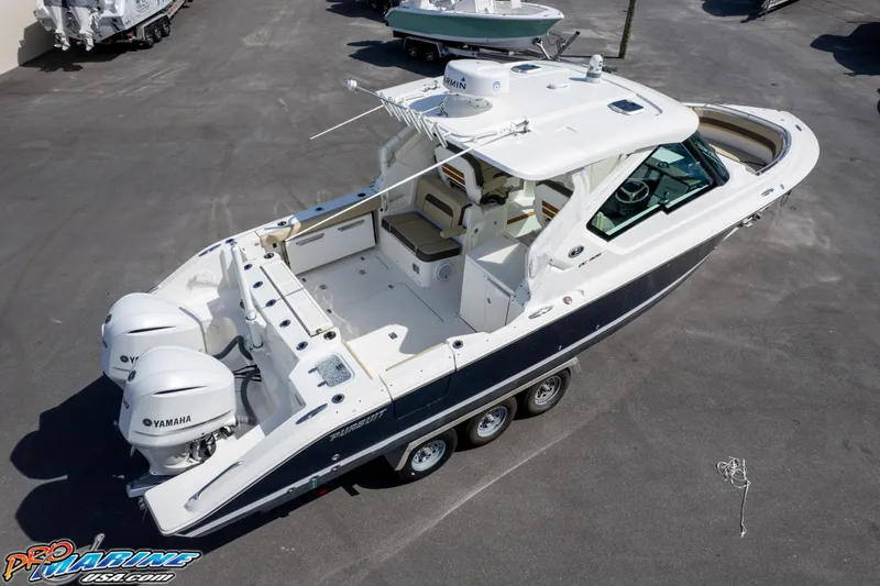 Slide: The Image of 2021 Pursuit DC 326 Dual Console boat with twin Yamaha engines, docked on a trailer. - 23