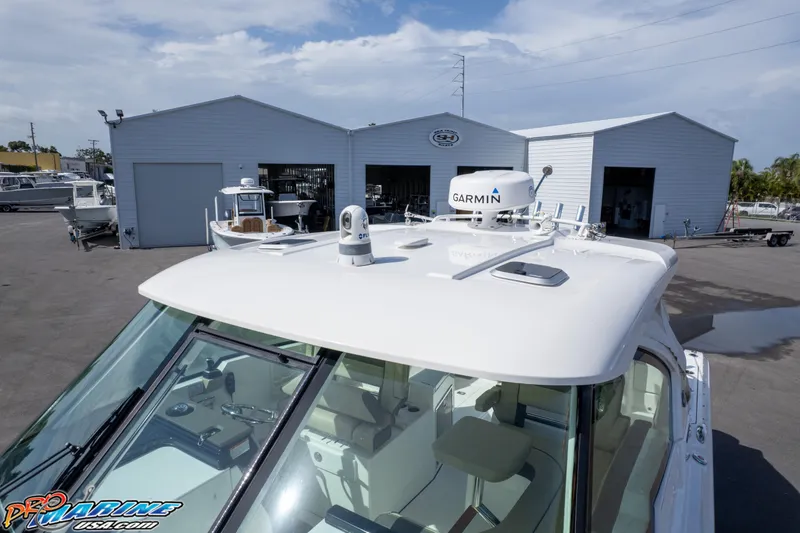 Slide: The Image of 2021 Pursuit DC 326 Dual Console boat with Garmin equipment, parked near storage buildings. - 30