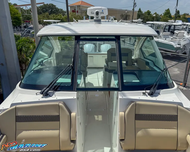 Slide: The Image of 2021 Pursuit DC 326 Dual Console boat with beige seating and Garmin equipment. - 42