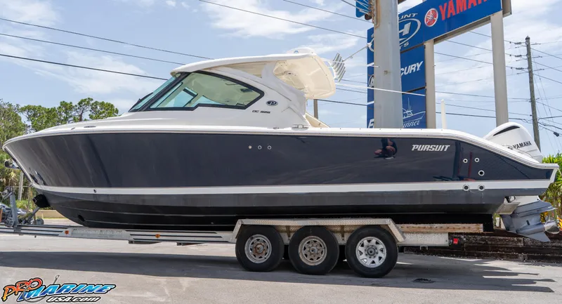Slide: The Image of 2021 Pursuit DC 326 Dual Console boat on a trailer at a dealership. - 6
