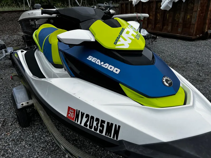 Slide: The Image of 2017 Sea-Doo Wake Pro 230 jet ski on trailer, vibrant blue and green design. - 2