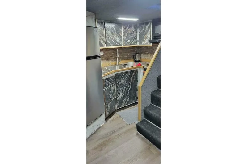 Slide: The Image of Modern kitchen interior in 2022 Custom Freestyle Marine 32 boat, featuring sleek cabinetry and appliances. - 16