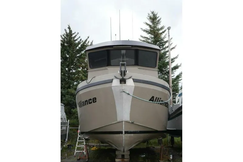 Slide: The Image of 2022 Custom Freestyle Marine 32 boat named "Alliance" on land, surrounded by trees. - 3