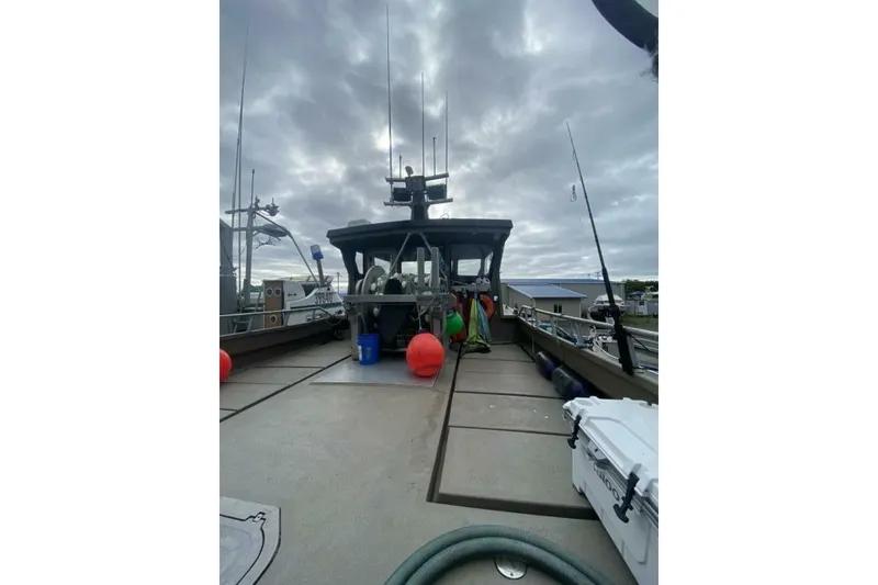 Slide: The Image of Custom Freestyle Marine 32 boat, 2022 model, docked under cloudy skies with marine equipment. - 34