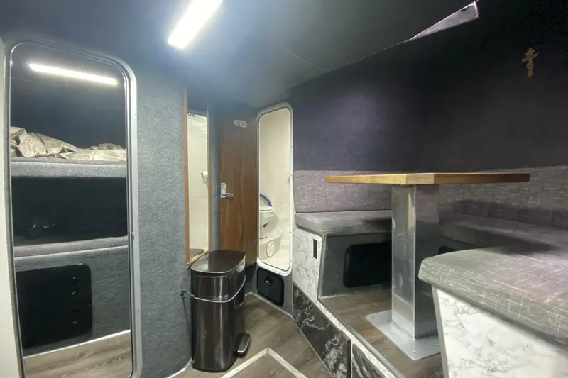 Slide: The Image of Interior of 2022 Custom Freestyle Marine 32, featuring cozy seating, bunk beds, and a compact bathroom. - 35