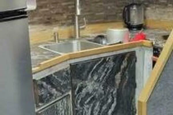 Slide: The Image of Modern kitchen area in a 2022 Custom Freestyle Marine 32 boat, featuring sleek countertops and appliances. - 36