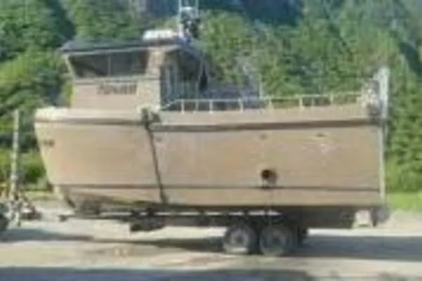 Slide: The Image of 2022 Custom Freestyle Marine 32 boat on trailer in a forested area. - 48