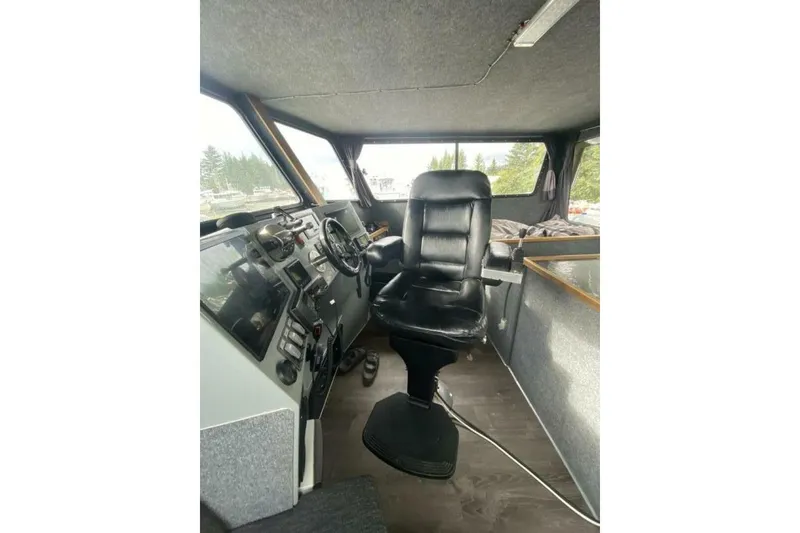 Slide: The Image of Interior of 2022 Custom Freestyle Marine 32 boat with black captain's chair and control panel. - 6