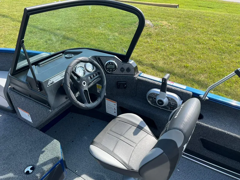 Slide: The Image of 2026 Lund 1675 Adventure Sport boat interior with steering wheel and control panel. - 11