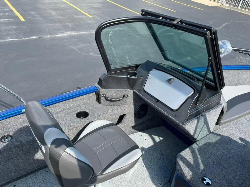 Slide: The Image of 2026 Lund 1675 Adventure Sport boat interior with seating and dashboard in a parking lot. - 12