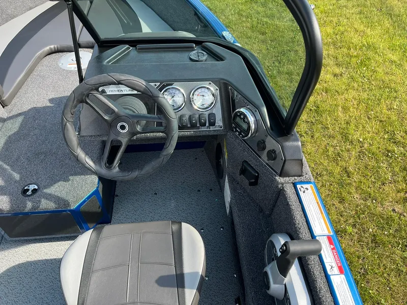 Slide: The Image of 2026 Lund 1675 Adventure Sport boat dashboard with steering wheel and controls. - 16