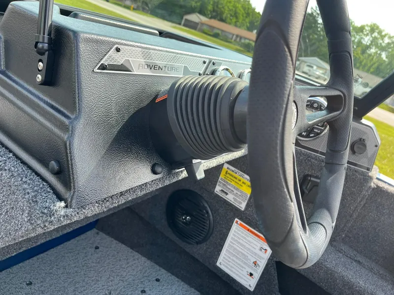 Slide: The Image of 2026 Lund 1675 Adventure Sport boat dashboard with steering wheel and controls. - 19