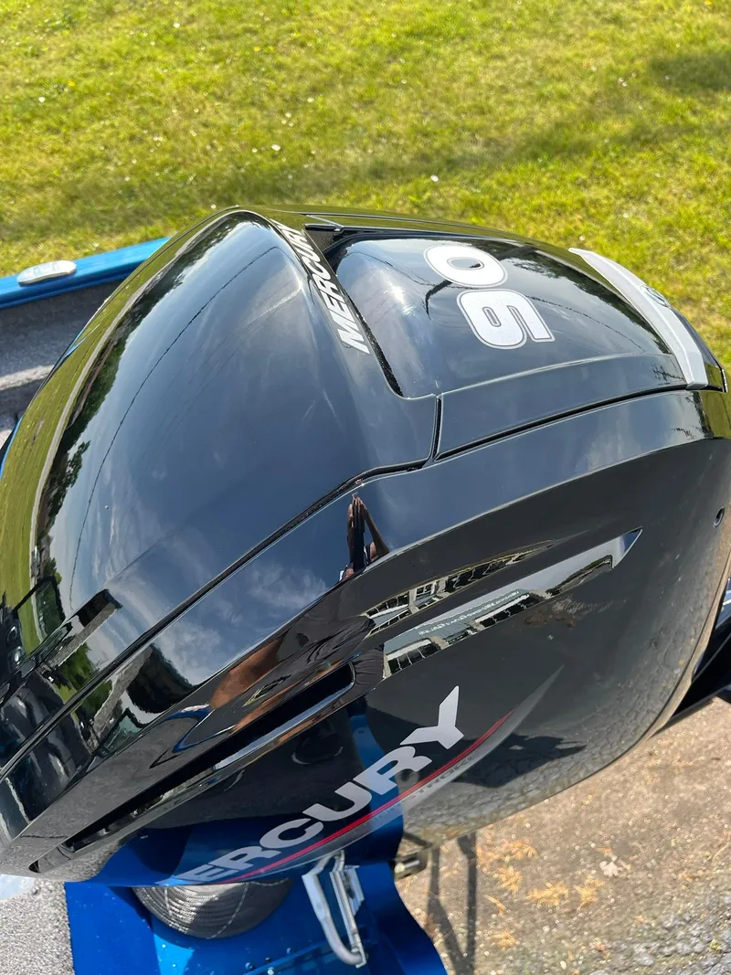 Slide: The Image of Mercury 90 outboard motor on 2026 Lund 1675 Adventure Sport boat, grassy background. - 25