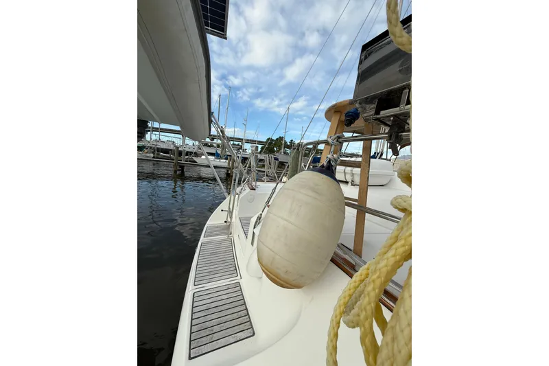 Slide: The Image of 1997 Beneteau Oceanis 40 CC sailboat docked, featuring deck view and fender. - 13