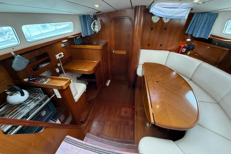 Slide: The Image of Interior of 1997 Beneteau Oceanis 40 CC yacht with wood finish and cozy seating area. - 16