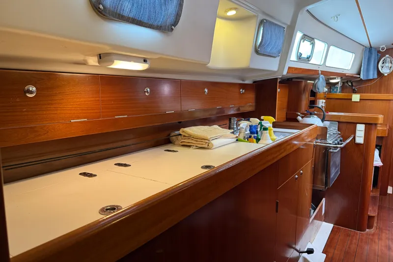 Slide: The Image of Interior of 1997 Beneteau Oceanis 40 CC yacht, featuring a well-equipped galley kitchen. - 29