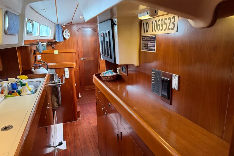 Slide: The Image of Interior of 1997 Beneteau Oceanis 40 CC yacht with wooden cabinetry and kitchen area. - 30