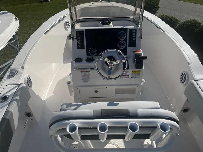 Slide: The Image of 2025 Robalo R180 Center Console boat interior with steering wheel and rod holders. - 5