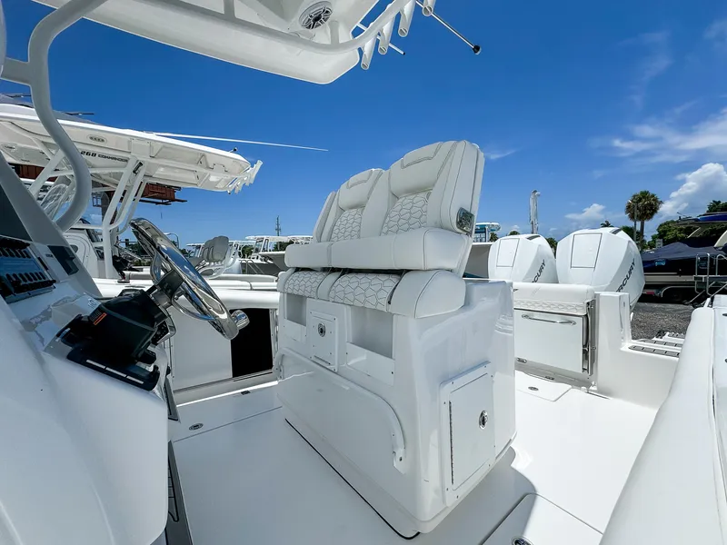 Slide: The Image of 2026 Tidewater 272 CC Adventure boat interior with white seating and steering wheel. - 4