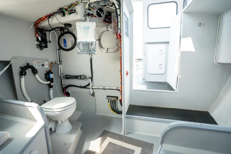 Slide: The Image of Interior of 2021 Beal Calvin Beal 25 Custom boat, featuring a compact marine toilet and utility area. - 21