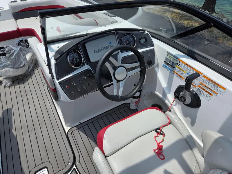 Slide: The Image of 2021 Hurricane SunDeck 217 OB boat dashboard with Garmin navigation system and steering wheel. - 13